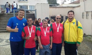 Atletas da Escola Municipal Heitor Villa lobos recebendo duas medalhas da prova do arremesso do peso. 